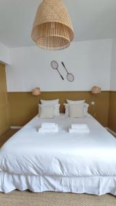 a bedroom with a white bed with a chandelier at Maison Charmeilles - La suite Saint Emilion in Fronsac