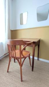 una silla de madera junto a un escritorio de madera en Maison Charmeilles - La suite Saint Emilion en Fronsac
