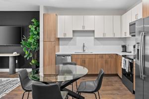 een keuken met een glazen tafel en stoelen bij Midnight Manor Penthouse Suite The Gulch in Nashville