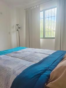 um quarto com uma cama azul e uma janela em CASA CORAZA em Cancún