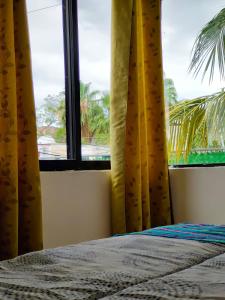 a bedroom with a bed and a window with a palm tree at CASA CORAZA in Cancún