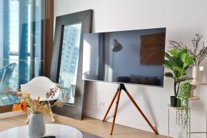 TV de pantalla plana en un trípode en la sala de estar en Chic Zenith Retreat -Vista, Skylight, Parking, en Sídney