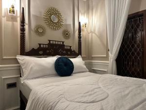 ein Schlafzimmer mit einem Bett mit einem blauen Kissen darauf in der Unterkunft The Heritage Kraton in Timuran