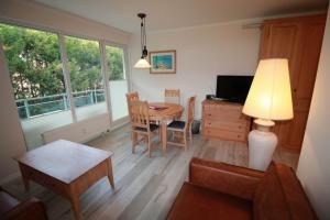 a living room with a table and a dining room at Apartment zum See in Ascheberg