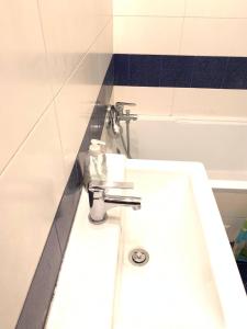 a white sink in a bathroom with blue and white tiles at FlatMetro Rooms in Budapest