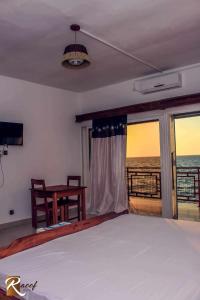 a bedroom with a bed and a view of the ocean at RAOOF HOTEL in Mahajanga