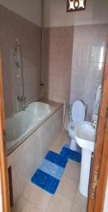 a bathroom with a tub and a toilet and a sink at RAOOF HOTEL in Mahajanga