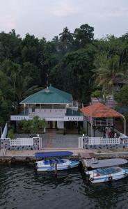 two boats docked at a dock in front of a building at LOVESHORE Homestay in Kollam