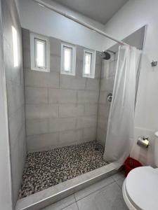 łazienka z prysznicem i kamienistą podłogą w obiekcie Villa Callarí w mieście El Zapote