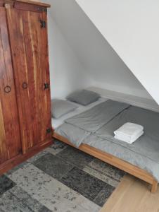 łóżko z drewnianą szafką w pokoju w obiekcie Attic apartment Catnip w Bratysławie