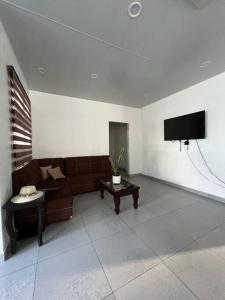 salon z kanapą i telewizorem z płaskim ekranem w obiekcie Villa Callarí w mieście El Zapote
