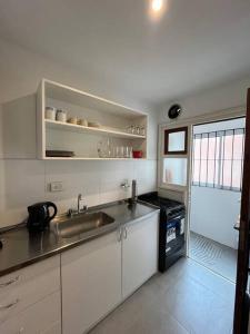 uma cozinha com um lavatório e um fogão em Departamento Los Troncos - Zona Güemes em Mar del Plata