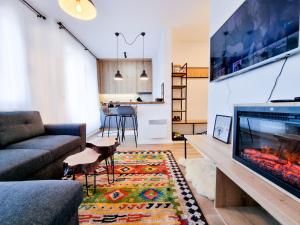 a living room with a couch and a tv at Vucko Slopes Apartment Bjelasnica in Bjelašnica
