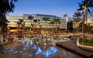 a group of people standing around a fountain in front of a building at Chic Zenith Retreat -Vista, Skylight, Parking in Sydney