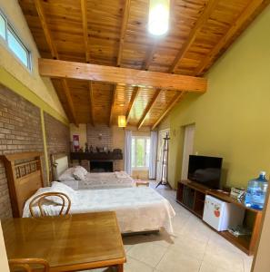um quarto com uma cama grande e um tecto de madeira em Hansi em General Alvear