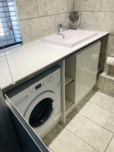 a white sink and a washing machine in a bathroom at Still Waters in Hill Head