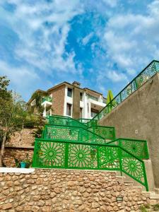 a green metal bench sitting on a stone staircase at Dar Zayane in Khenifra