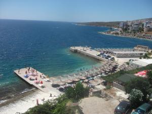 an aerial view of a beach with umbrellas and the ocean at Hotel Piccolino in Sarandë
