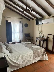 a bedroom with a large bed and a window at Hotel La Hoya del Tajo in Ronda