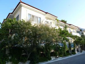 un edificio blanco con árboles frente a una calle en Paris Beach Hotel, en Iräon