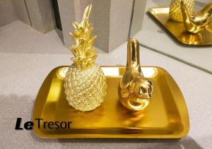 a gold plate with a pineapple on top of it at Le Tresor Benson Apartment at Supermal Pakuwon in Surabaya
