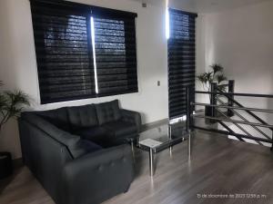 a living room with a couch and a glass table at Departamento Glorieta in Mazamitla