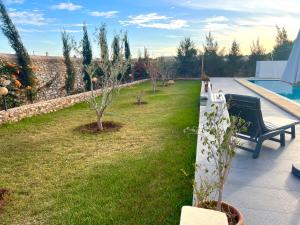 um jardim com um banco e árvores e uma piscina em Bidani Villa em Essaouira