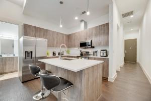 a kitchen with a white counter and two chairs at Chic loft style 2BR I Gym I Parking I Workspace in Dallas