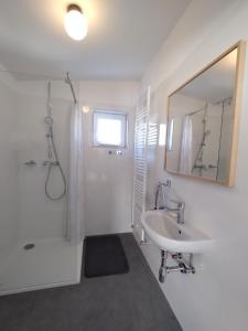 biała łazienka z umywalką i lustrem w obiekcie Attic apartment Catnip w Bratysławie