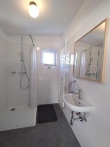 a white bathroom with a sink and a mirror at Attic apartment Cathouse in Bratislava