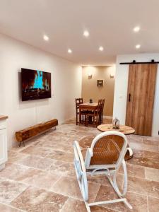 a living room with chairs and a table and a tv at Maison Aveny Spa 