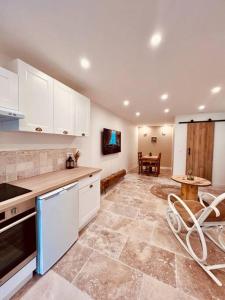 a kitchen with white cabinets and a table with chairs at Maison Aveny Spa in Aveny