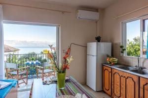 a kitchen with a refrigerator and a view of the ocean at MAKAROUNIS THEA II in Petalidhion