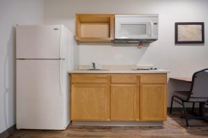 a kitchen with a white refrigerator and a sink at WoodSpring Suites Lexington Southeast in Lexington