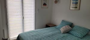 um quarto com uma cama com um edredão azul em New house on the seafront em Hermanville-sur-Mer