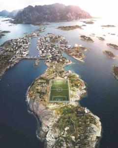 an island with a soccer field in the water at Ny leilighet i Henningsvær! in Henningsvær
