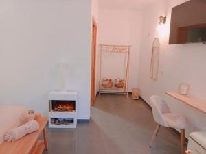 Villa Morena في فينيسترات: غرفة معيشة بها موقد وطاولة وكراسي