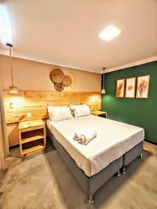 um quarto com uma cama grande e uma parede verde em Vila Aju - Pousada Temática em Aracaju