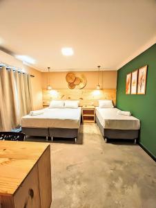 2 camas en una habitación con paredes verdes en Vila Aju - Pousada Temática, en Aracaju