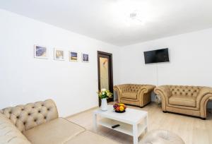 Sala de estar con 2 sofás y mesa en Apartament Brazda - Rendez Vous, en Craiova