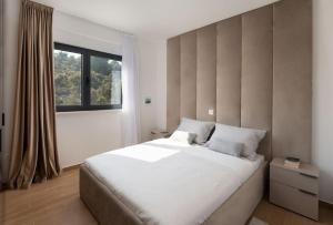 a bedroom with a large white bed and a window at Villa Palm Bay 2, heated pool - 10 m from the sea in Ražanj +31 photos