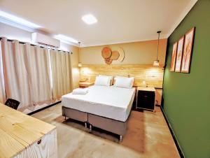 a bedroom with a bed and a green wall at Vila Aju - Pousada Temática in Aracaju