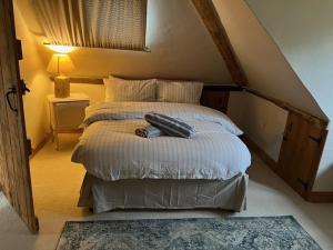 a bedroom with a bed in a attic at Thatched Cottage in Ashford