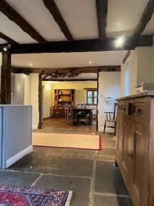 a kitchen and dining room with a table and chairs at Thatched Cottage in Ashford