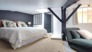 a bedroom with a bed and a couch at Maison Charmeilles - Gîte touristique - Villa in Fronsac