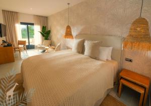 a bedroom with a large white bed with pillows at Alcaidesa Boutique Hotel in La Alcaidesa