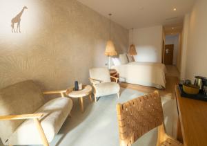 a hotel room with a bed and chairs and a bedroom at Alcaidesa Boutique Hotel in La Alcaidesa
