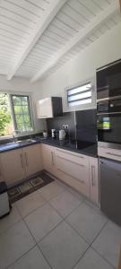 uma cozinha com balcões e electrodomésticos a preto e branco em An'Kanna em Petit-Bourg
