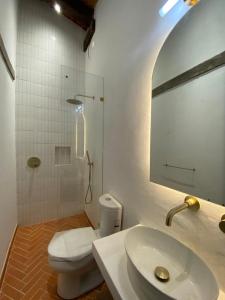 bagno con servizi igienici, lavandino e specchio di Villa del Lago a Pátzcuaro