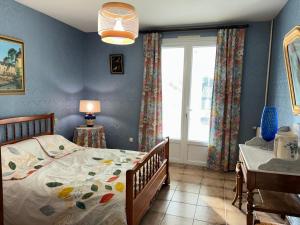 Schlafzimmer mit einem Bett und einem Fenster in der Unterkunft Les clés de Jonzacconciergerie, Villa les oiseaux in Jonzac